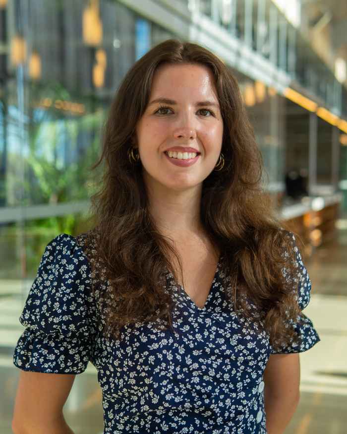 Student met bruin haar lachend in de camera